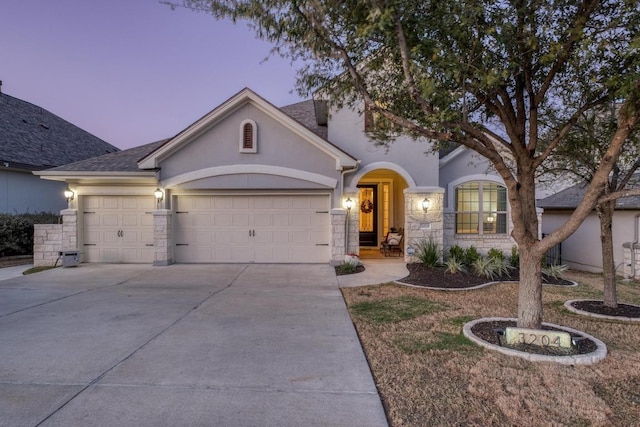 3204 Venezia Vw, Leander, TX 78641 - view of front facade with a garage, stucco siding, concrete driveway, stone siding, and a shingled roof