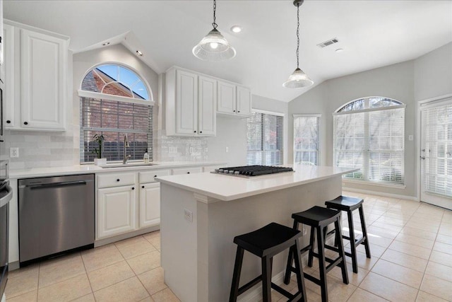 5201 Keene Cv, Austin, TX 78730 - kitchen featuring appliances with stainless steel finishes, vaulted ceiling, healthy amount of natural light, light tile patterned flooring, and tasteful backsplash