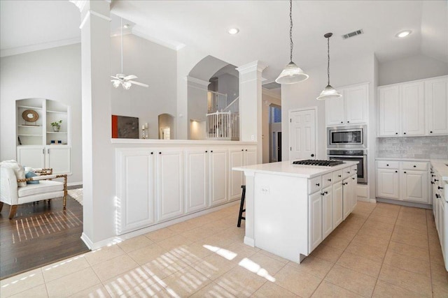 5201 Keene Cv, Austin, TX 78730 - kitchen with stainless steel appliances, decorative columns, light tile patterned floors, arched walkways, and light countertops