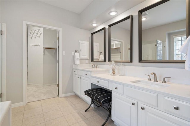 5201 Keene Cv, Austin, TX 78730 - bathroom with a walk in closet, double vanity, baseboards, and a shower