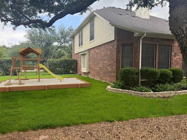 5201 Keene Cv, Austin, TX 78730 - view of property exterior featuring brick siding, a playground, roof with shingles, and a yard