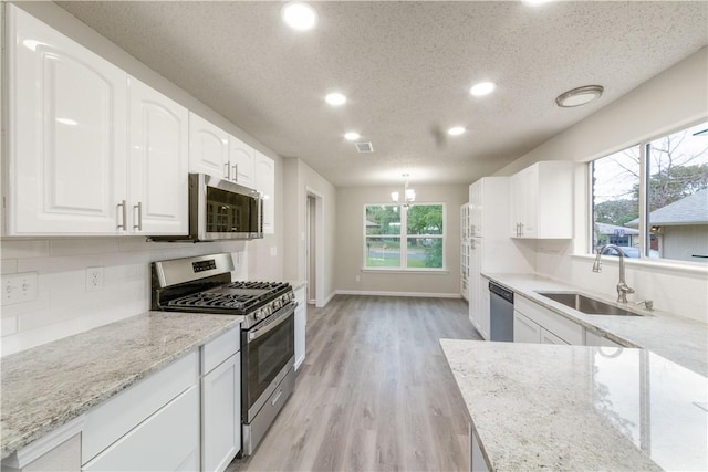 3901 Skipton Dr, Austin, TX 78727 - kitchen with stainless steel appliances, recessed lighting, light stone counters, tasteful backsplash, and a textured ceiling