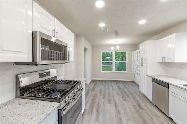 3901 Skipton Dr, Austin, TX 78727 - kitchen featuring stainless steel appliances, backsplash, white cabinetry, recessed lighting, and light wood finished floors