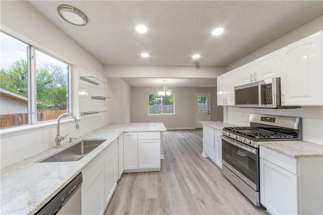 3901 Skipton Dr, Austin, TX 78727 - kitchen featuring stainless steel appliances, recessed lighting, light wood-style floors, backsplash, and white cabinets