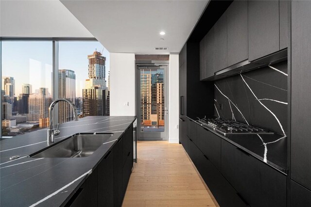 44 E Ave Unit 3203, Austin, TX 78701 - kitchen featuring a sink, dark cabinetry, modern cabinets, a view of skyline, and recessed lighting