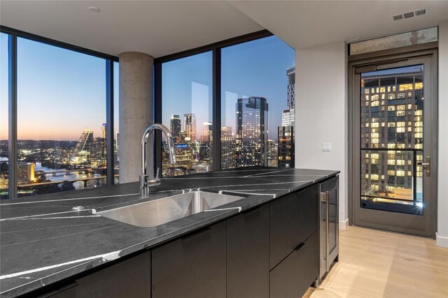 44 E Ave Unit 3203, Austin, TX 78701 - kitchen featuring a skyline view, a sink, modern cabinets, beverage cooler, and floor to ceiling windows