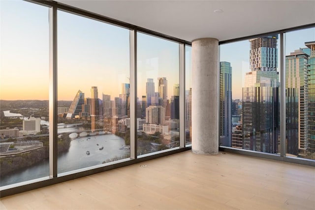 44 E Ave Unit 3203, Austin, TX 78701 - empty room featuring floor to ceiling windows, a view of skyline, wood finished floors, and a water view