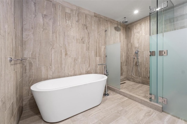 44 E Ave Unit 3203, Austin, TX 78701 - full bath featuring tile walls, a stall shower, and a freestanding tub