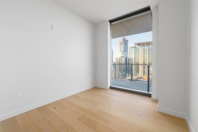 44 E Ave Unit 3203, Austin, TX 78701 - unfurnished room with floor to ceiling windows, light wood finished floors, baseboards, and a view of city