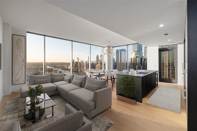 44 E Ave Unit 3203, Austin, TX 78701 - living area with light wood-style floors, a skyline view, a wall of windows, a chandelier, and healthy amount of natural light