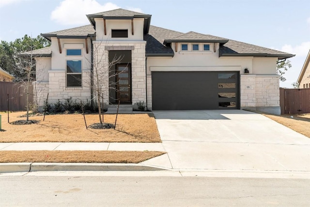 129 Du Bois Ln, Kyle, TX 78640 - view of front of house featuring stone siding, stucco siding, concrete driveway, a shingled roof, and a garage
