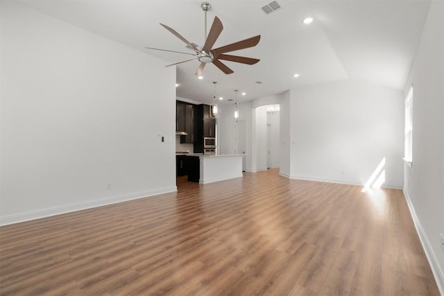 129 Du Bois Ln, Kyle, TX 78640 - unfurnished living room with ceiling fan, light wood-type flooring, vaulted ceiling, baseboards, and recessed lighting
