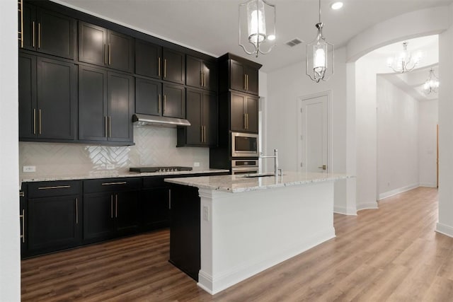 129 Du Bois Ln, Kyle, TX 78640 - kitchen with a chandelier, a sink, appliances with stainless steel finishes, light stone countertops, and decorative backsplash
