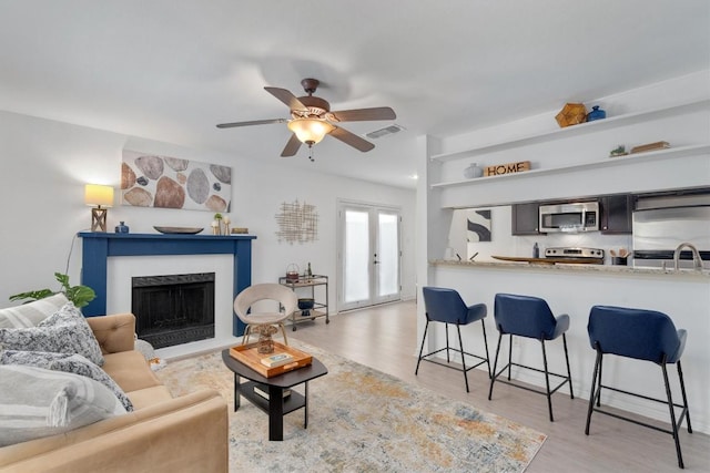 6700 Cooper Ln Unit 30, Austin, TX 78745 - living room with light wood finished floors, ceiling fan, and a high end fireplace