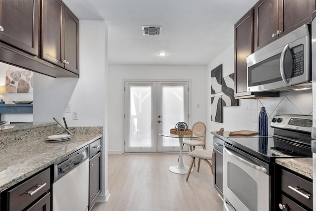 6700 Cooper Ln Unit 30, Austin, TX 78745 - kitchen featuring stainless steel appliances, dark brown cabinets, light wood-type flooring, light stone counters, and french doors
