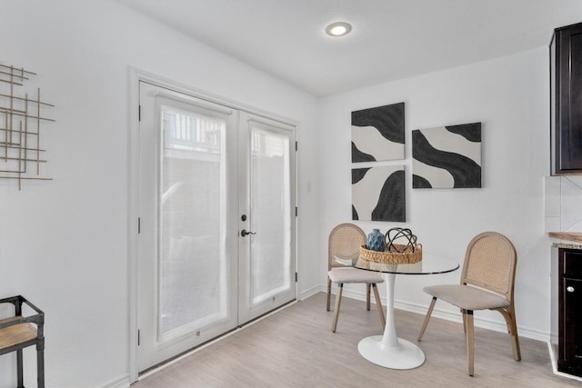 sitting room featuring french doors, light wood finished floors, baseboards, and recessed lighting