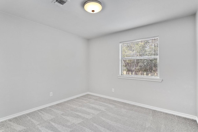 carpeted spare room featuring baseboards