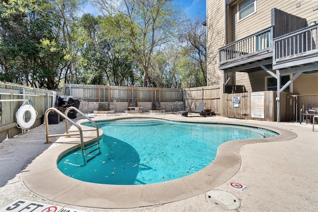 community pool with a fenced backyard and a patio