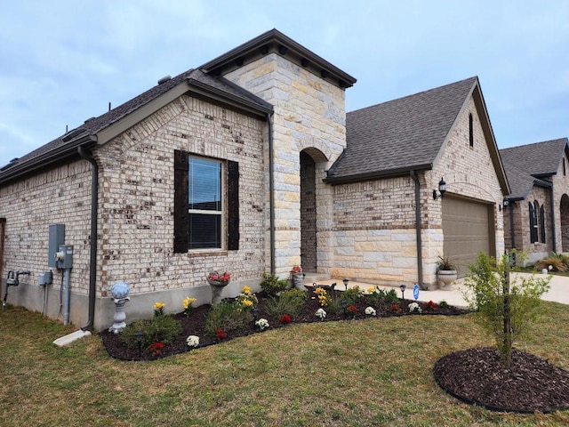 view of front facade with roof with shingles, stone siding, a front lawn, an attached garage, and concrete driveway