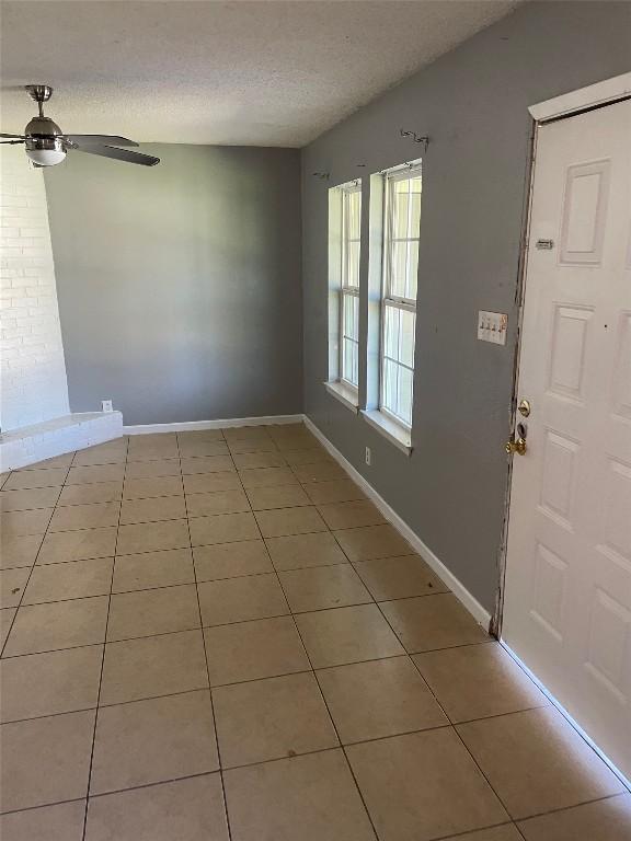 905 Fieldwood Dr, Austin, TX 78758 - foyer entrance with a textured ceiling, light tile patterned floors, a ceiling fan, and baseboards