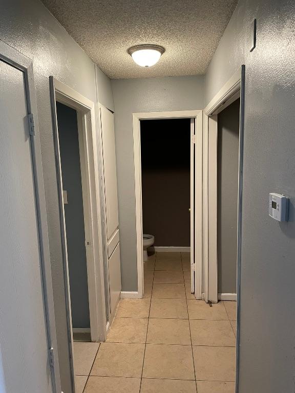 905 Fieldwood Dr, Austin, TX 78758 - hall featuring light tile patterned floors and a textured ceiling