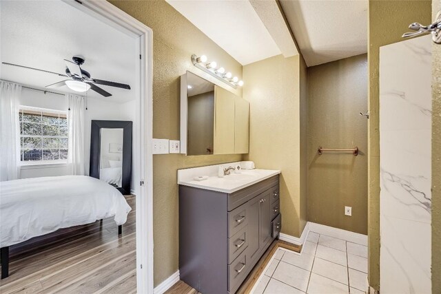 618 Bentwood Dr, Leander, TX 78641 - bathroom featuring tile patterned flooring, vanity, baseboards, ensuite bath, and a ceiling fan