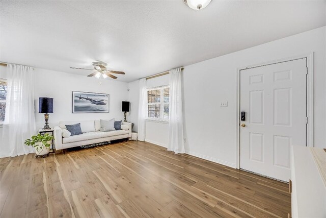 618 Bentwood Dr, Leander, TX 78641 - unfurnished living room featuring a ceiling fan, baseboards, and light wood-style floors