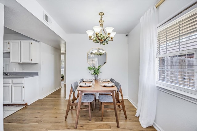 618 Bentwood Dr, Leander, TX 78641 - dining space with baseboards, visible vents, a notable chandelier, and light wood finished floors