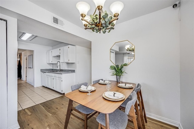 618 Bentwood Dr, Leander, TX 78641 - dining area with light wood finished floors, baseboards, visible vents, and a chandelier