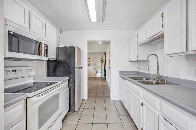 618 Bentwood Dr, Leander, TX 78641 - kitchen with light countertops, a sink, light tile patterned floors, white appliances, and white cabinets