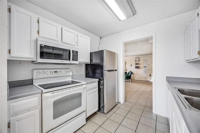 618 Bentwood Dr, Leander, TX 78641 - kitchen with light tile patterned flooring, light countertops, white electric stove, white cabinetry, and freestanding refrigerator