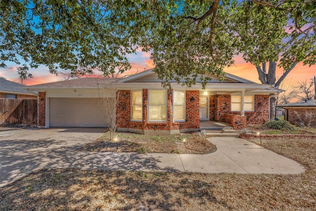 201 Apache Dr, Temple, TX 76504 - ranch-style home with a garage, brick siding, concrete driveway, and fence