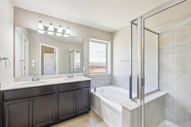 bathroom with a garden tub, a sink, tile patterned floors, and a stall shower