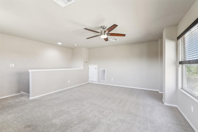 carpeted empty room featuring visible vents, a ceiling fan, and baseboards