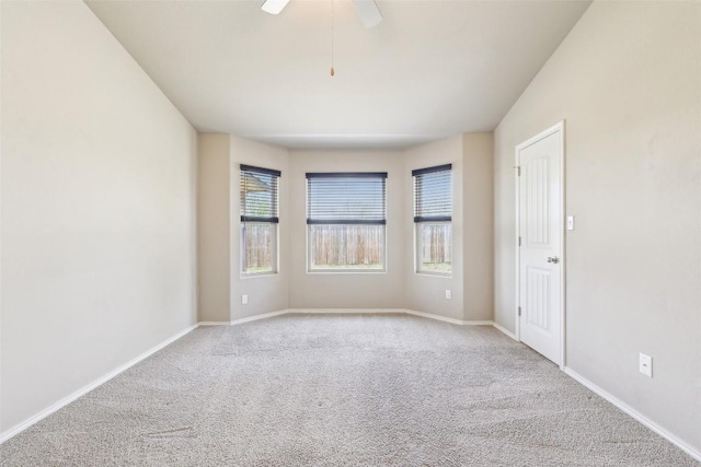 empty room with carpet floors, baseboards, and ceiling fan