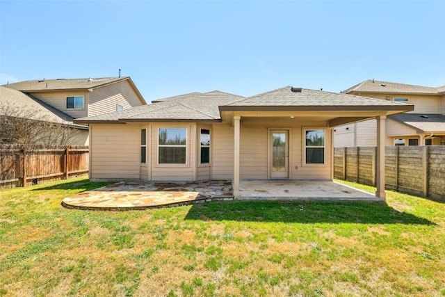 rear view of property featuring a fenced backyard, a lawn, and a patio area