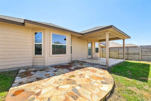 rear view of property featuring a patio and a fenced backyard