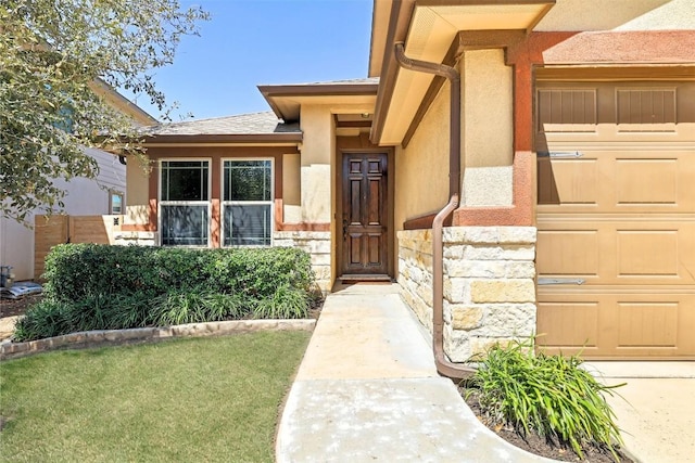 doorway to property featuring a lawn, a garage, stucco siding, and stone siding