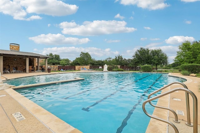 community pool featuring a patio area and fence