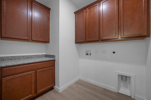 laundry room with baseboards, light wood-style floors, hookup for a gas dryer, cabinet space, and electric dryer hookup