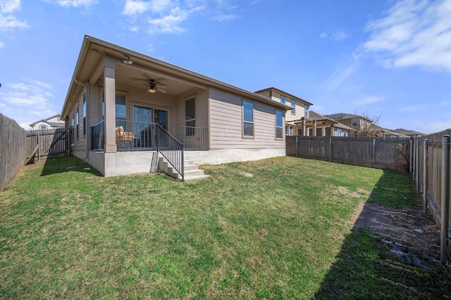 rear view of property featuring a fenced backyard, a lawn, and ceiling fan