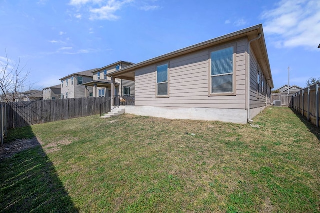 back of house with a lawn and a fenced backyard