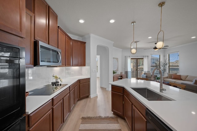 kitchen with black appliances, a sink, tasteful backsplash, arched walkways, and ceiling fan