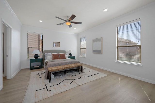 bedroom with light wood finished floors, multiple windows, and crown molding