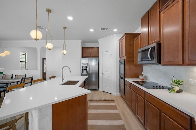 kitchen featuring a kitchen island with sink, black appliances, visible vents, and a sink