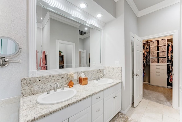 14904 Oak Shores Dr, Willis, TX 77318 - bathroom with crown molding, double vanity, a walk in closet, tile patterned flooring, and recessed lighting