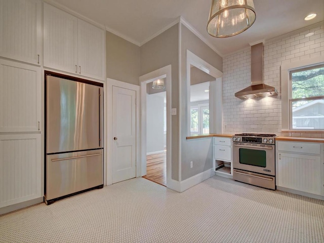 1203 W 22 1/2 St, Austin, TX 78705 - kitchen featuring appliances with stainless steel finishes, wall chimney exhaust hood, crown molding, light carpet, and light countertops