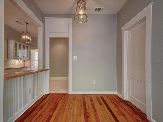 1203 W 22 1/2 St, Austin, TX 78705 - unfurnished dining area with wood finished floors, baseboards, and a chandelier