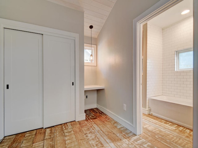 1203 W 22 1/2 St, Austin, TX 78705 - unfurnished bedroom with light wood-style floors, a closet, vaulted ceiling, baseboards, and ensuite bath