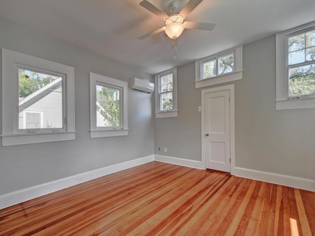 1203 W 22 1/2 St, Austin, TX 78705 - empty room featuring a wall unit AC, baseboards, light wood finished floors, and a ceiling fan